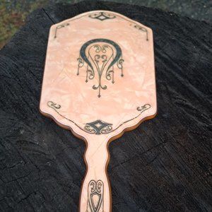Vintage art deco pearlized bakelite handheld mirror with black etching.